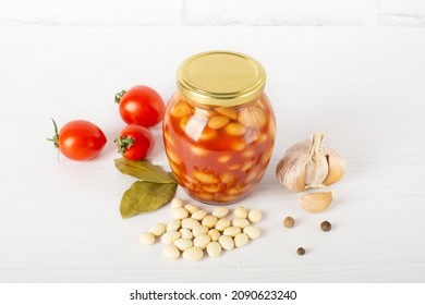 Canned Beans In Tomato Sauce In A Glass Jar On A White Table