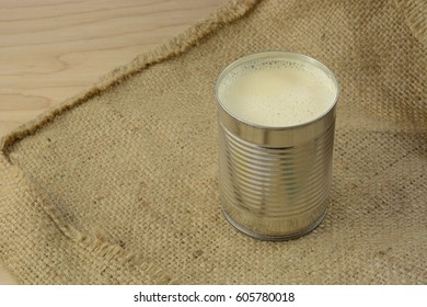 Canned Evaporated Milk In Open Can On Burlap