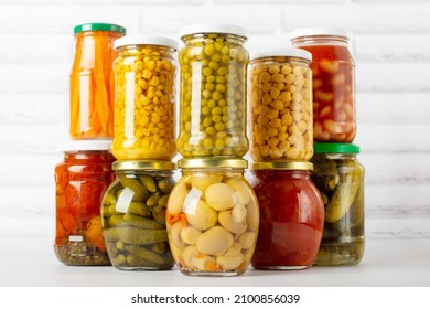canned food on a white background, different types of canned vegetables in glass jars - Shutterstock ID 2100856039