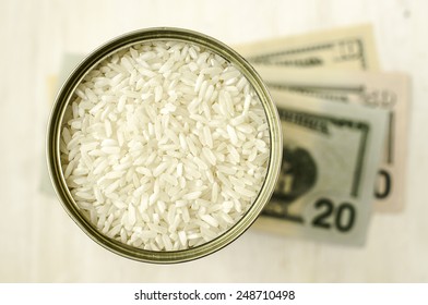 Canned Long Grain Rice In A Tin Cans And Dollars. The Concept Of Price Or Commodity Exchange