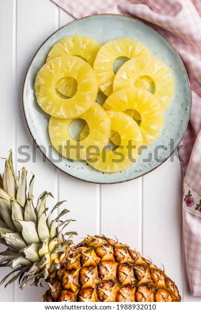 Canned sliced\
pineapple fruit on plate. Top\
view.