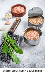 Canned Tuna In A Can, Whole And Chopped. Grey Wooden Background. Top View