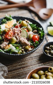 Canned Tuna Salad With Fresh Vegetables, Capers And Olives In A Black Bowl. Healthy Lunch Or Dinner.