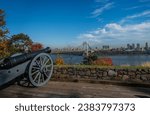 A cannon in the Fort Lee Historic Park, with New York city in the background in Autumn
