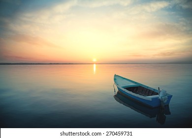 Canoe floating on the calm water under amazing sunset - Shutterstock ID 270459731