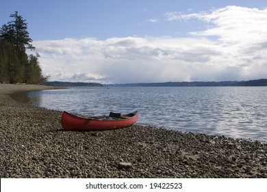 Canoe grounded on the shores of Burfoot Park with the waters of Budd Inlet (South end of the Puget Sound) leading to the Capital City of Olympia Washington in the distance.