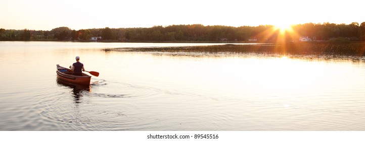 Canoe On Lake With Setting Sun