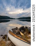 Canoe on the rocky shore of a lake at sunset in  Algonquin Provincial Park Canada