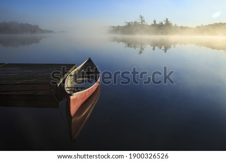 Canoe reflected in the still lake
