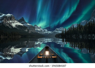 Canoeing with Aurora Borealis over mountain range in Maligne Lake at Jasper national park, Canada. Fine art concept