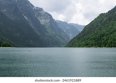 Canoeing on a Pristine Alpine Lake with Lush Green Forests and Rugged Mountain Scenery - Powered by Shutterstock