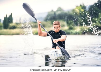 Canoeist man sitting in canoe paddling, in water. Concept of canoeing as dynamic and adventurous sport. Rear view, sportman looking at water surface, paddling - Powered by Shutterstock