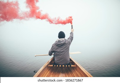 Canoeist using smoke bomb to signal his position on the foggy lake