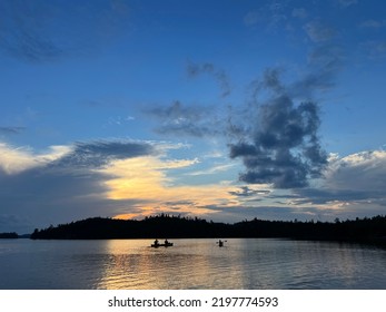 Canoeists Paddle At Dusk On The Boundary Waters. Minnesota.