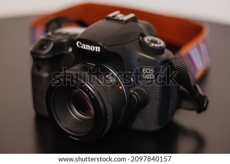 Canon eos 60d camera. The camera and a lens on a black bakcground