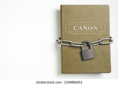 Canons. Book With Lock. A Closed Book Is Banned. Chain And Padlock Wrapped The Book.