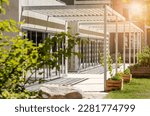 Canopy Awning on Entrance Building. Aluminum Pergola Garden by Modern House with Glass Facade Windows. 