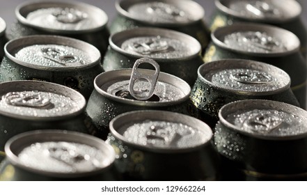 Cans of beer with selective focus on center opened can.