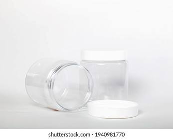 Cans for storing bulk products with white lids on light isolated background. Transparent plastic container with lid for storing food and bulk product. An empty jar for food. Copy space