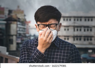 Can't breathe. Man wearing the respiratory protection mask against air pollution and dust particles exceed the safety limits. Healthcare, environmental, ecology concept. Allergy, headache. - Powered by Shutterstock