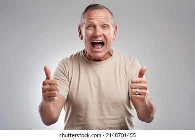 It Cant Get Better Than A Double Thumbs Up. Shot Of A Handsome Mature Man Standing Against A Grey Background In The Studio And Making A Thumbs Up Gesture.