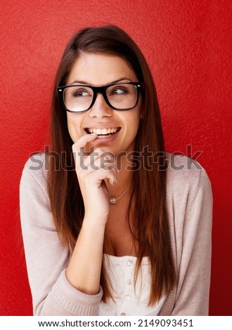 I cant wait. Cropped view of a young woman wearing glasses and looking away with a smile.