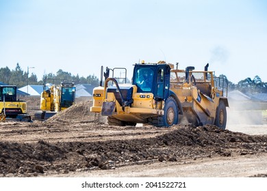 Canterbury, New Zealand, September 12 2021: A Large Yellow Earthmover Works Levelling Out The Soil For A New Housing Subdivision