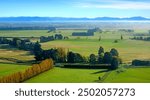 Canterbury Plains aerial view as the mist clears on an Autumn morning, New Zealand. In the background are the Southern Alps.