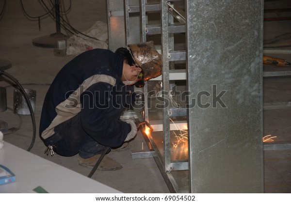 CANTON, CHINA -\
NOVEMBER 11: One of the biggest manufacturer of auto spray booths\
and generators in China. Welder working on aluminum frame on\
November 11, 2010 in Canton,\
China.