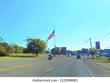 Canton, TX, USA - October 14, 2017: Rider Biker On Motorcycle, Cars On The Road And A American Flag.
Traffic In A Countryside Near Canton In Texas In Summer Sunny Day.