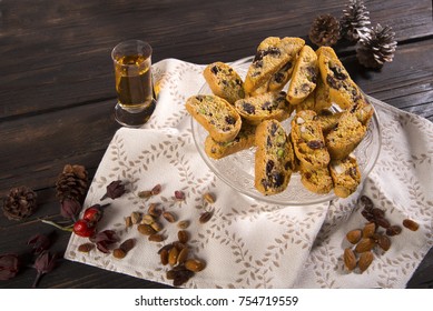 Cantucci assorted with pistachio nuts, almonds, cranberries, chocolate, hazelnuts, and vinsanto on a wooden table