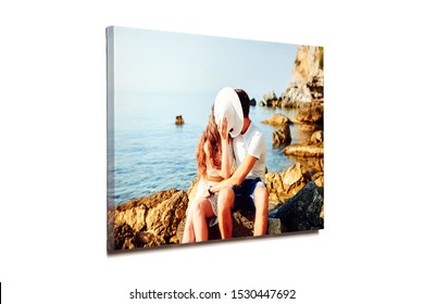 Canvas photo print isolated on white background. Colorful engagement photography with gallery wrap. Photo of kissing couple in love printed on glossy canvas