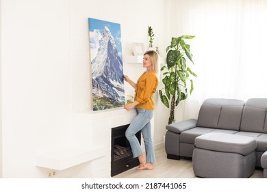 Canvas Print With Gallery Wrap Interior Decor. Woman Hangs Landscape Photography On White Wall. Hands Holding Photo Canvas Print