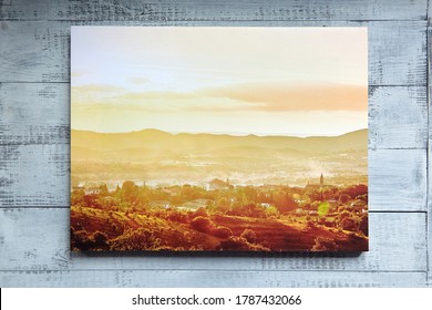 Canvas print hang on wooden wall. Stretched canvas on frame. Summer french landscape photography. Photo printed on canvas, front view