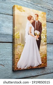 Canvas Print Hanging On Light Blue Wooden Wall. Photo Printed On Canvas. Wedding Portrait, Photography Stretched On Stretcher Bar With Gallery Wrap