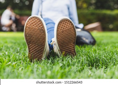 Canvas Shoes Soles Of A Girl Sitting On The Grass In A Park - Teenager Relaxing And Enjoying The Leisure On A Public Domain Space In The City