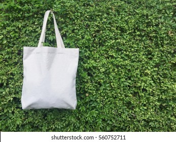 Canvas tote bag hanging on leaf wall. - Powered by Shutterstock