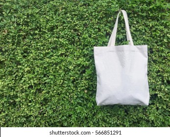 A canvas tote bag hanging on leaf wall. - Powered by Shutterstock