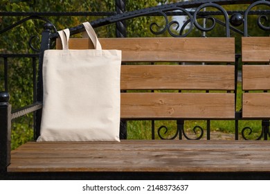 Canvas tote bag on the garden bench mockup. Rustic linen shopper bag mock up for branding presentation