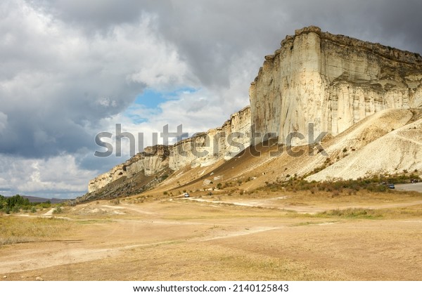 A canyon with a\
sheer cliff and white limestone on a cloudy day. Copy space.       \
                       