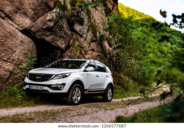 Canyon Temska, Serbia - 09.21.2018 / SUV car Kia\
Sportage 2.0 CRDI awd or 4x4, in the canyon next to a large rock,\
on a dusty road. 