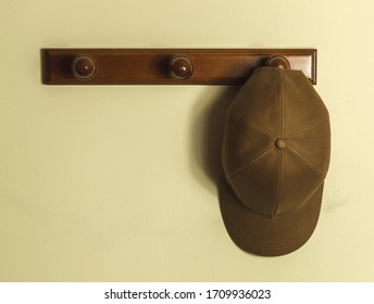 Cap Hanging On A Wooden Hat Rack At Empty Wall