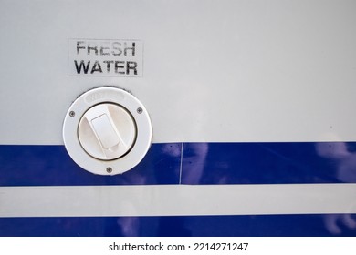 Cap Providing Access To The Fresh Water Storage Tank On A Camper Van, White Body Work With Blue Line Decoration