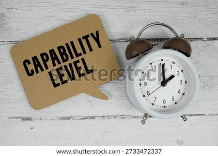 Capability Level text with alarm clock on wooden background