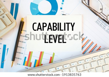 Capability level is written in a document on the office desk with office accessories, diagram and keyboard