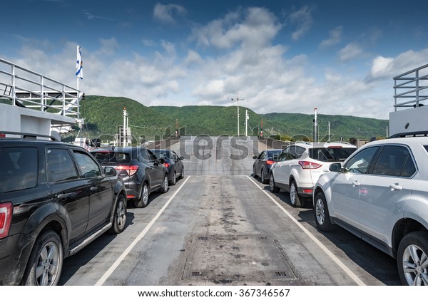 CAPE BRETON, CANADA - SEP 15,\
2015: Cars on the Englishtown ferry head towards the Cabot\
Trail