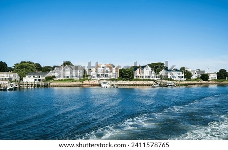 Cape Cod coastal background showing the boats and beach, with valuable real estate houses along the shore