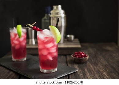 Cape Codder Cocktail with lime and ice. Cranberry and vodka alcohol Cape Codder Cocktail on dark wooden background. - Powered by Shutterstock