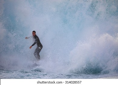 CAPE SOLANDER, AUSTRALIA - AUGUST 27, 2015; Surfer riding through a massive wave as it crashes around him at Cape Solander - Shutterstock ID 314028557