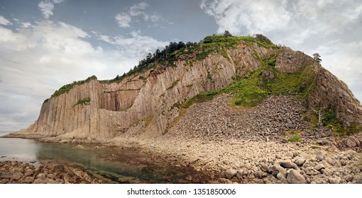 Cape Stolbchaty, geographic cape on the east shore of Kunashir Island of Sakhalin Oblast, Russia. Composed of layers of basaltic lavas of the Mendeleyev volcano. - Shutterstock ID 1351850006